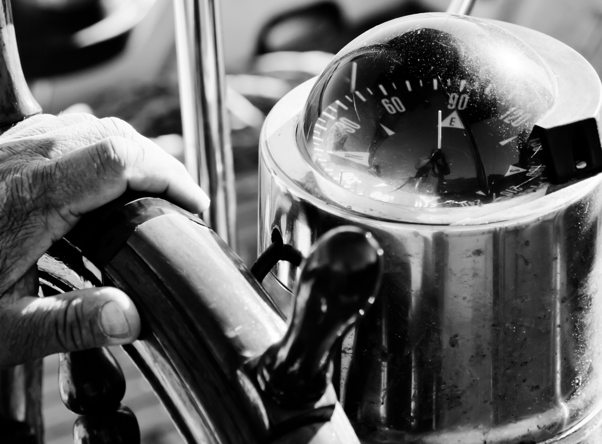 Ship compass and hand on the helm